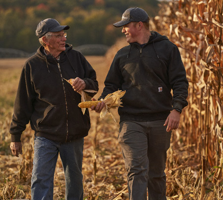 Multigenerational farmers walking next to crops image 多代农民走在农作物旁